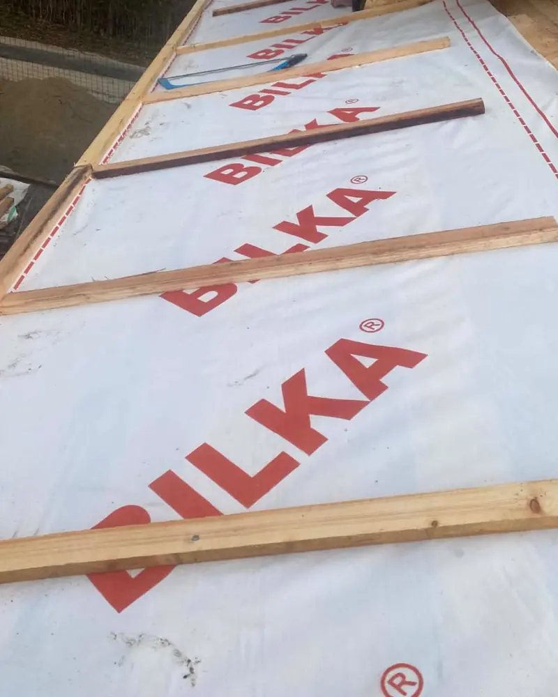 Folie albă cu marca Bilka tipărită, cu șipci bătute peste ea