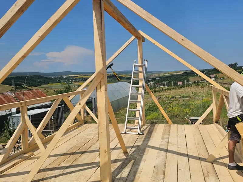 Ferme de lemn și o podină nouă, cu o scară și dealurile în spate
